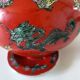 Vintage red Chinese teapot decorated with dragons and symbols.