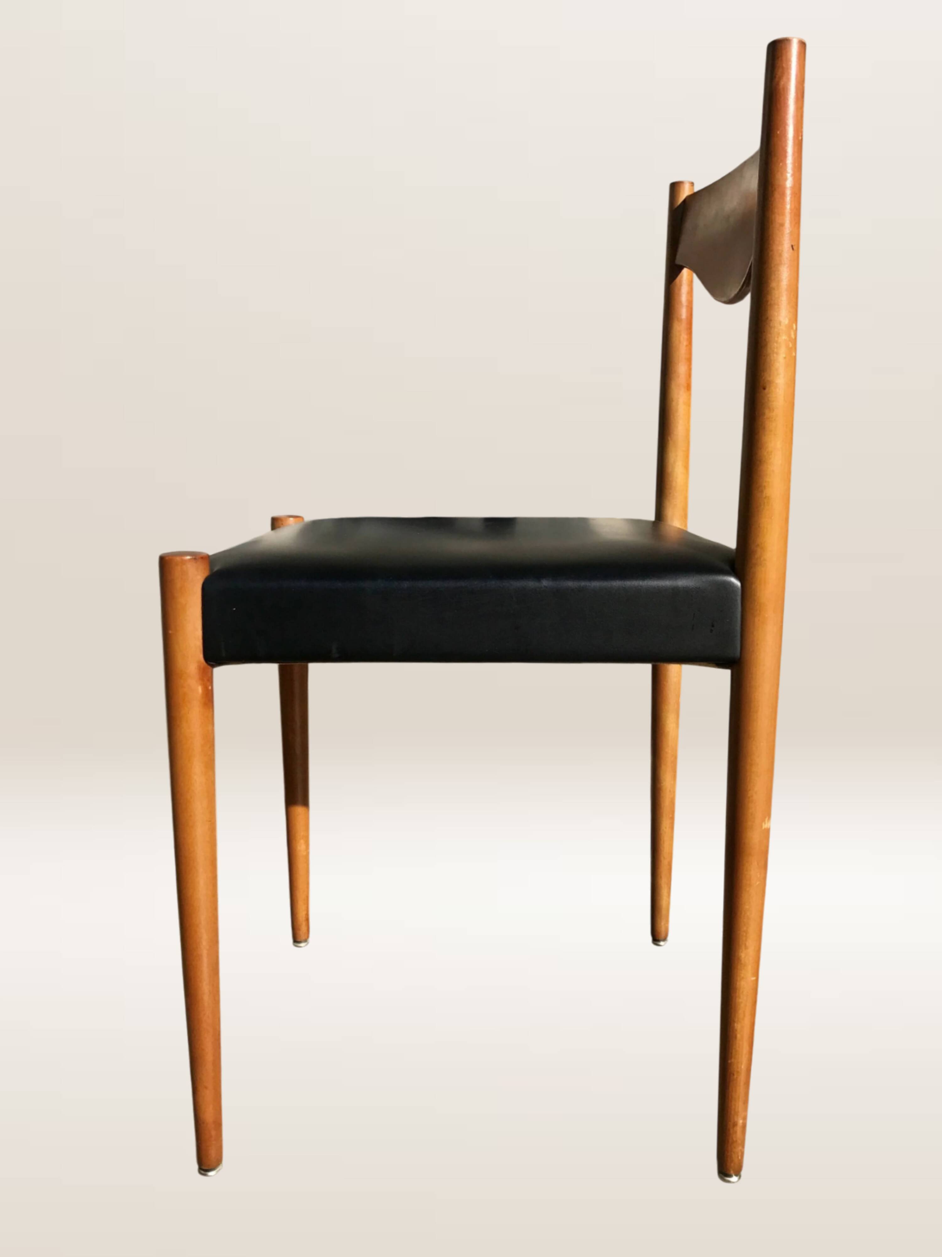 Set of 6 modernist chairs with black faux leather seats.