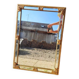 Large mirror with beveled facets in gilded wood from the early 20th century