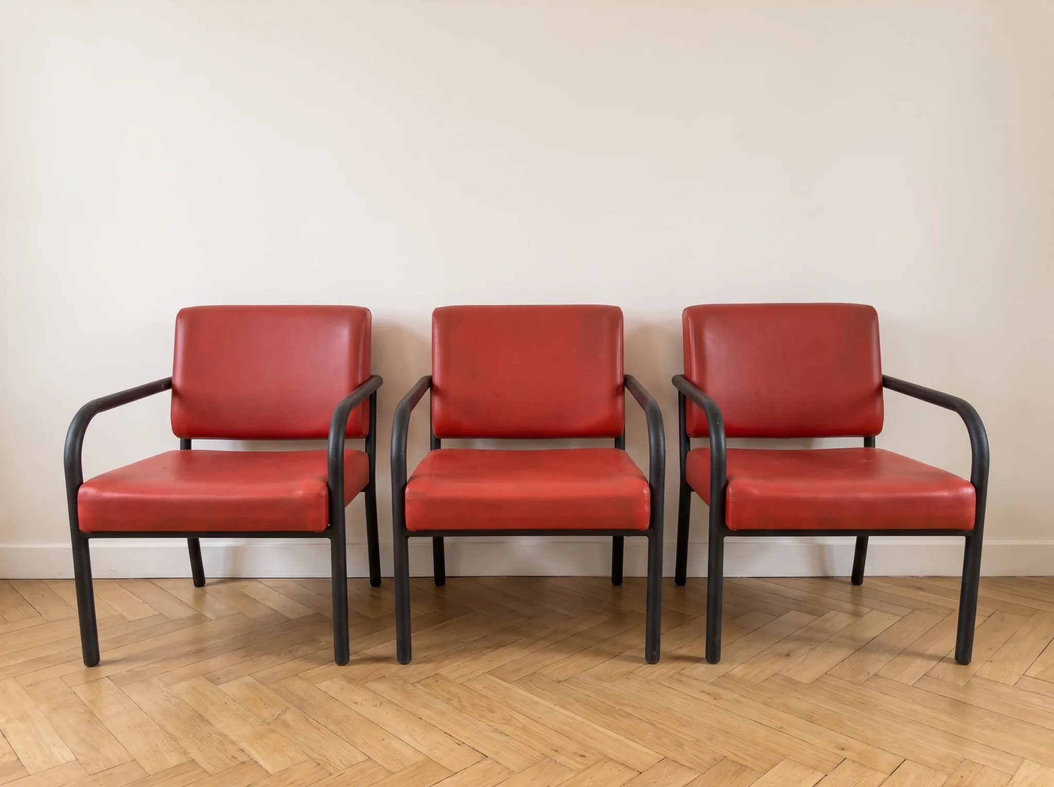 3 red leather and metal armchairs