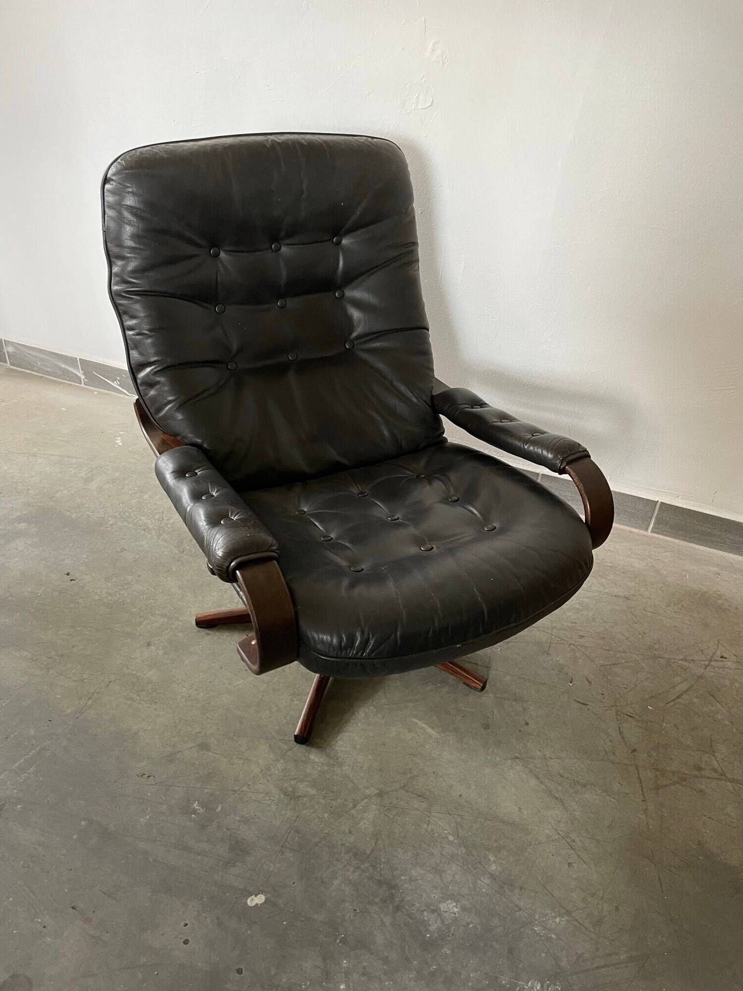 Scandinavian swivel lounge chair in black leather with a bent wood frame, 1970s.