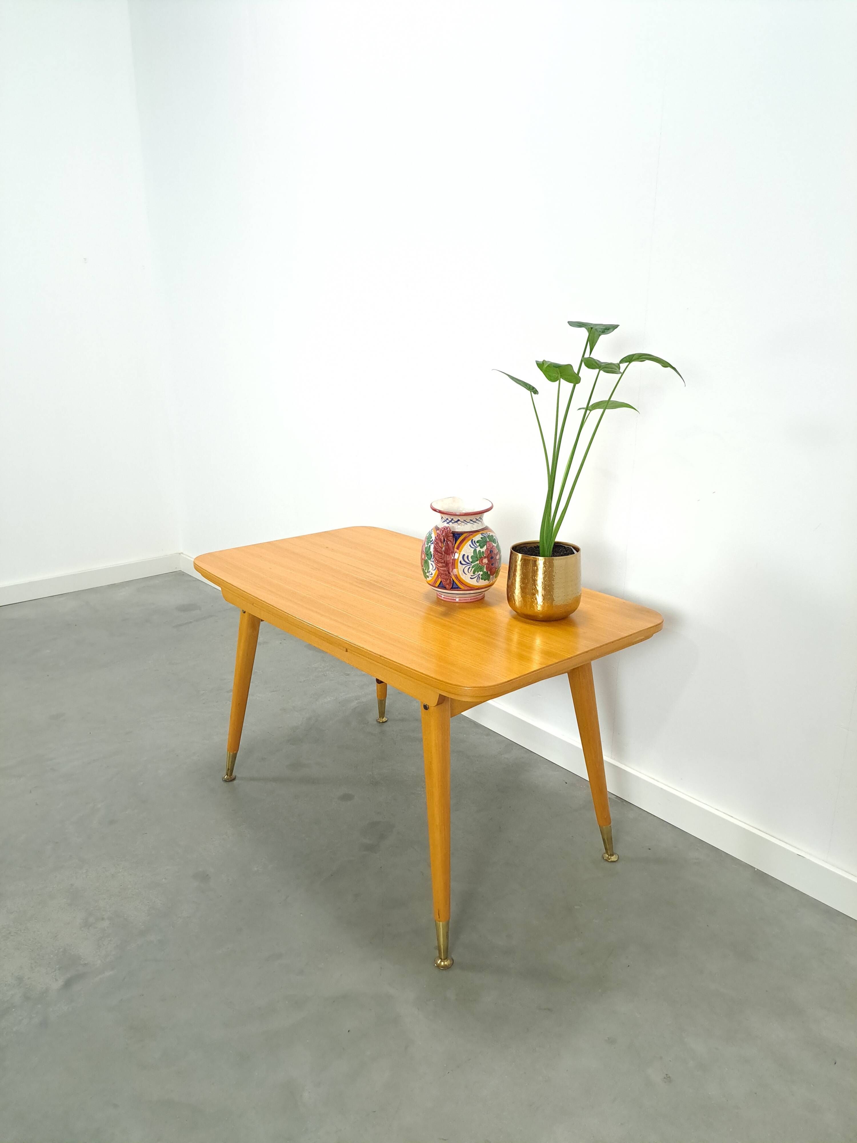 Vintage veneer table with pretty angular legs and brass at the base of the legs.