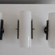 Set of four wall lights in white plexiglass and perforated black metal.
