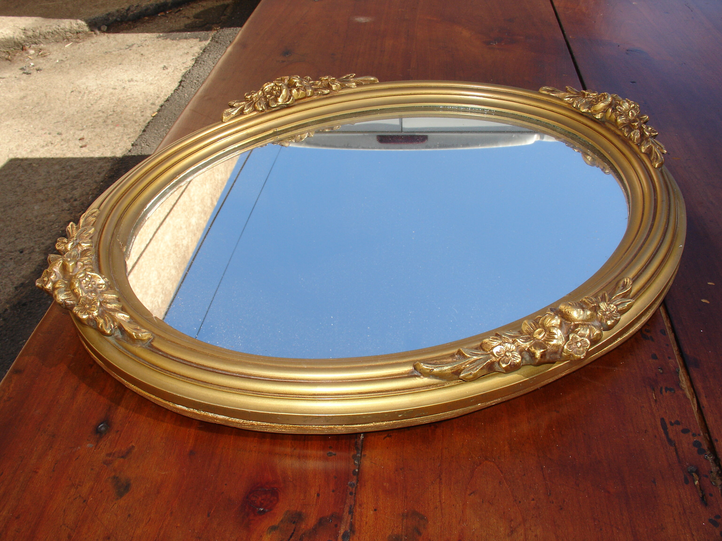 Oval gilt mirror, 30 x 44 cm, with floral decoration, circa 1930