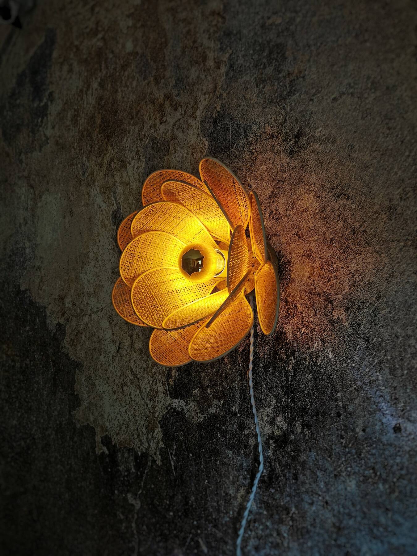 Flower wall light made of rattan and raffia petals