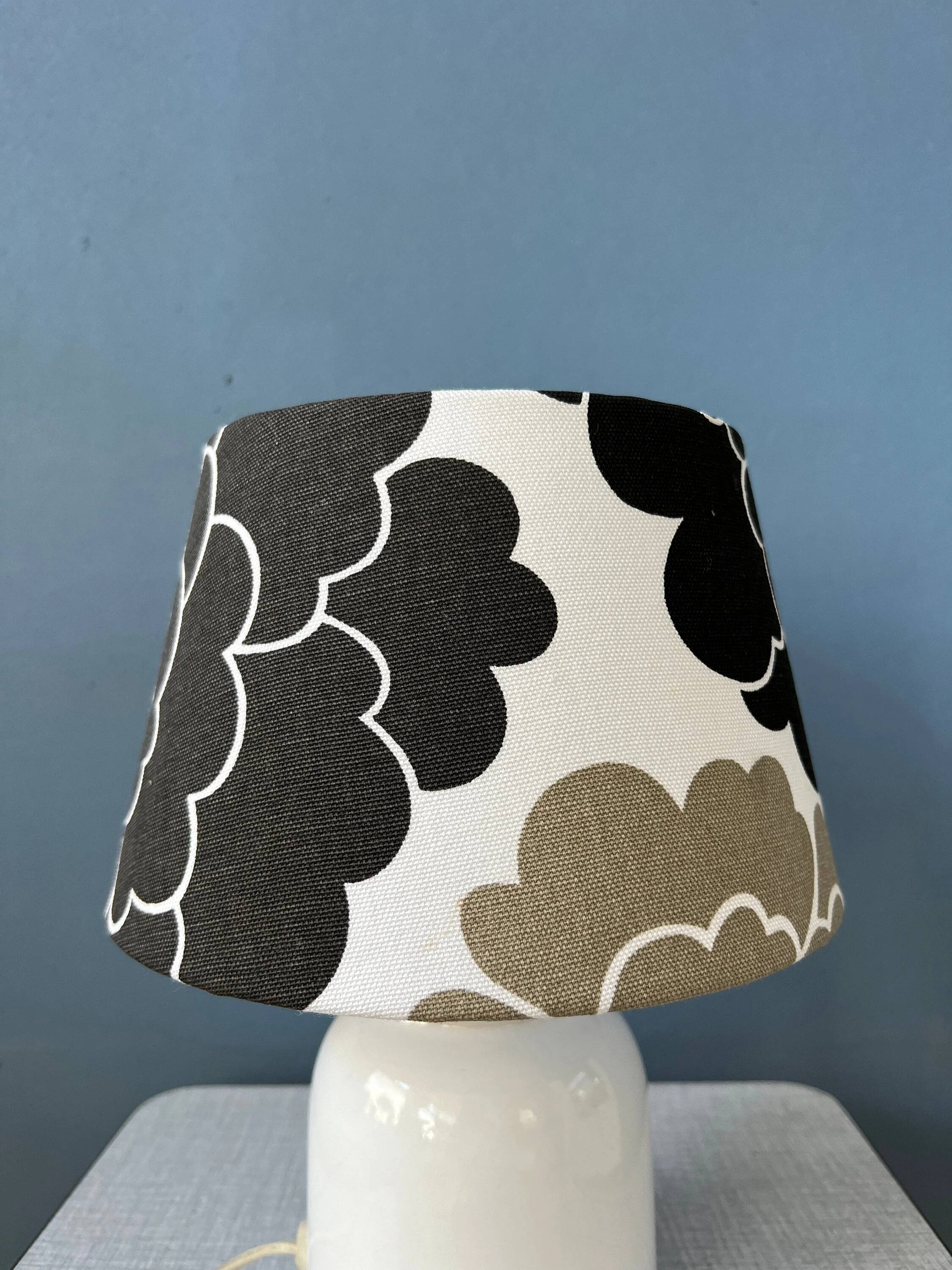 Small Space Age table lamp with a porcelain base and black and white flower shade.