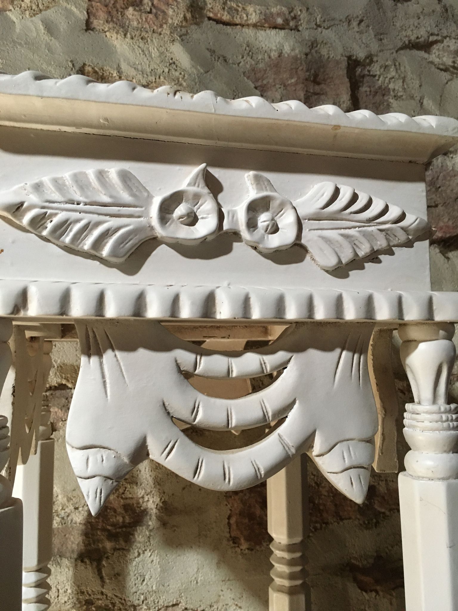 Carved wooden stool with a white patina.