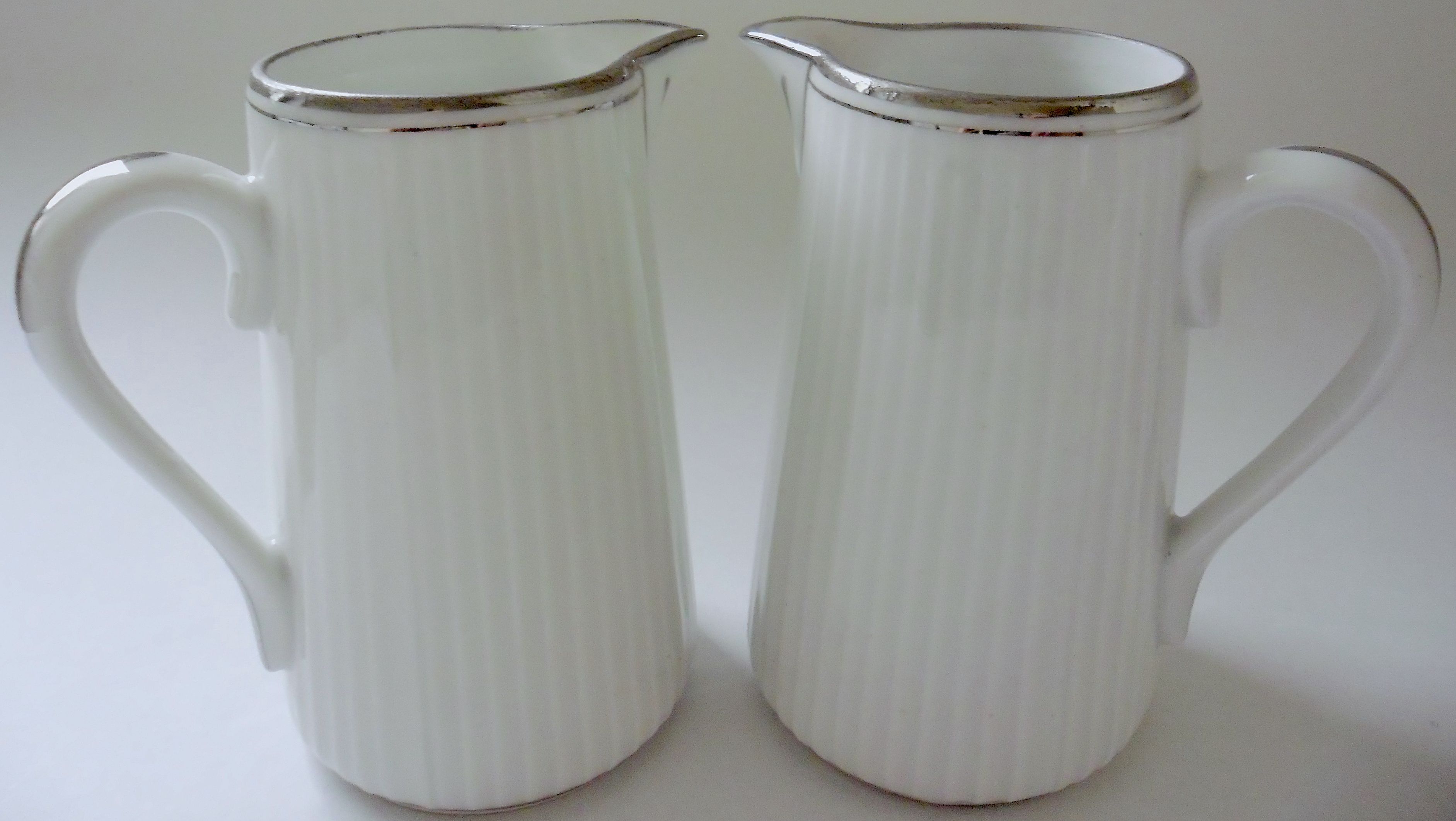 Pair of creamers in white porcelain enhanced with platinum