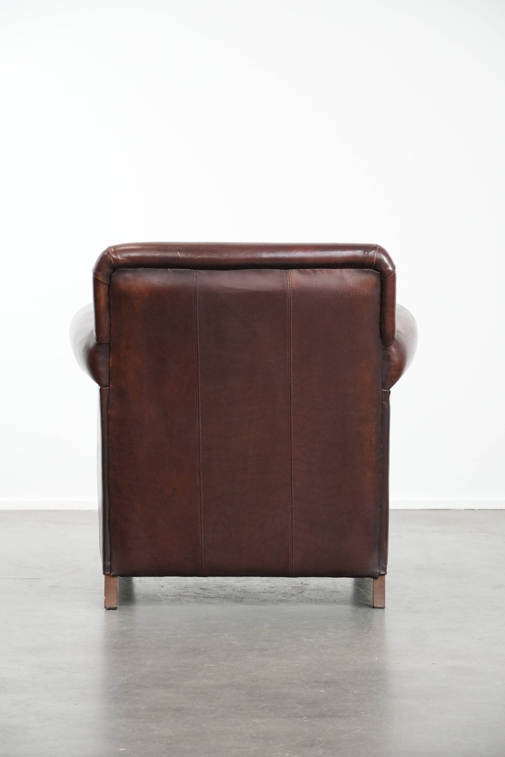 Sheepskin armchair with a classic finish and decorative studs.