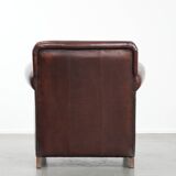 Sheepskin armchair with a classic finish and decorative studs.