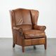 Cognac-coloured wingback armchair in English style made of cowhide leather