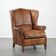 Cognac-coloured wingback armchair in English style made of cowhide leather