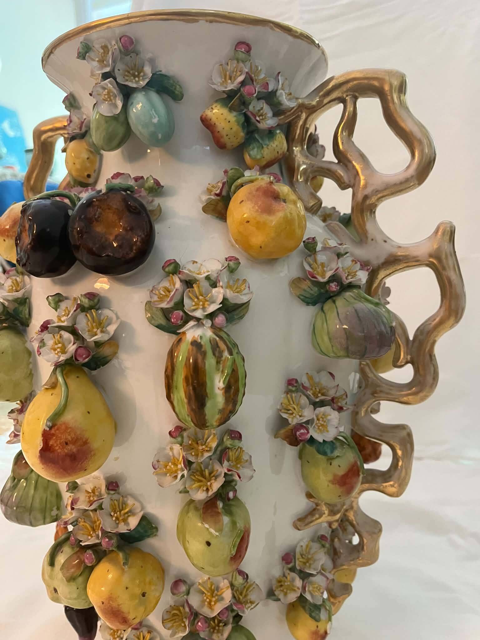 Large antique vase with relief decorations of coloured fruits.