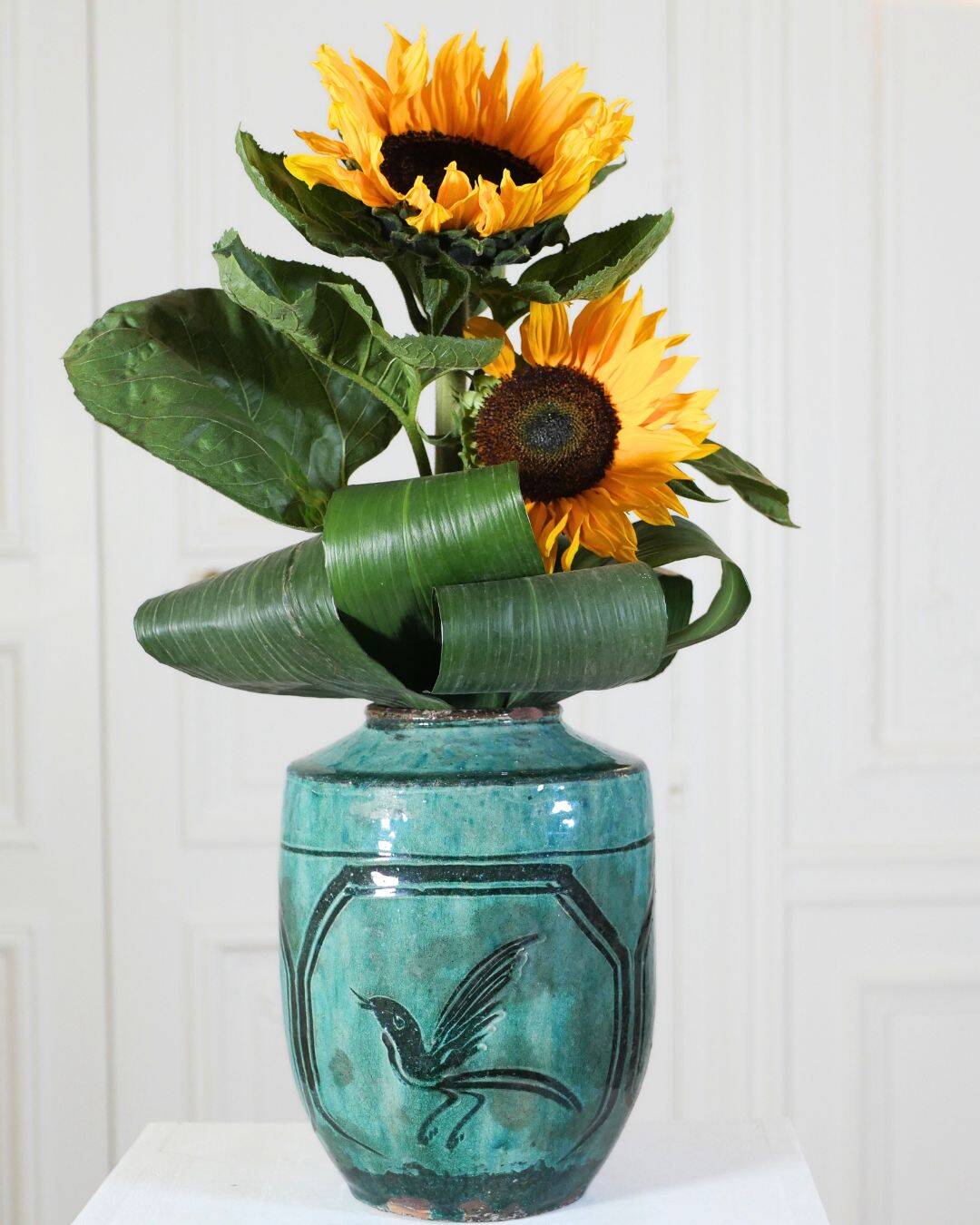 Chinese glazed earthenware vase with bird and flower decoration on a green background