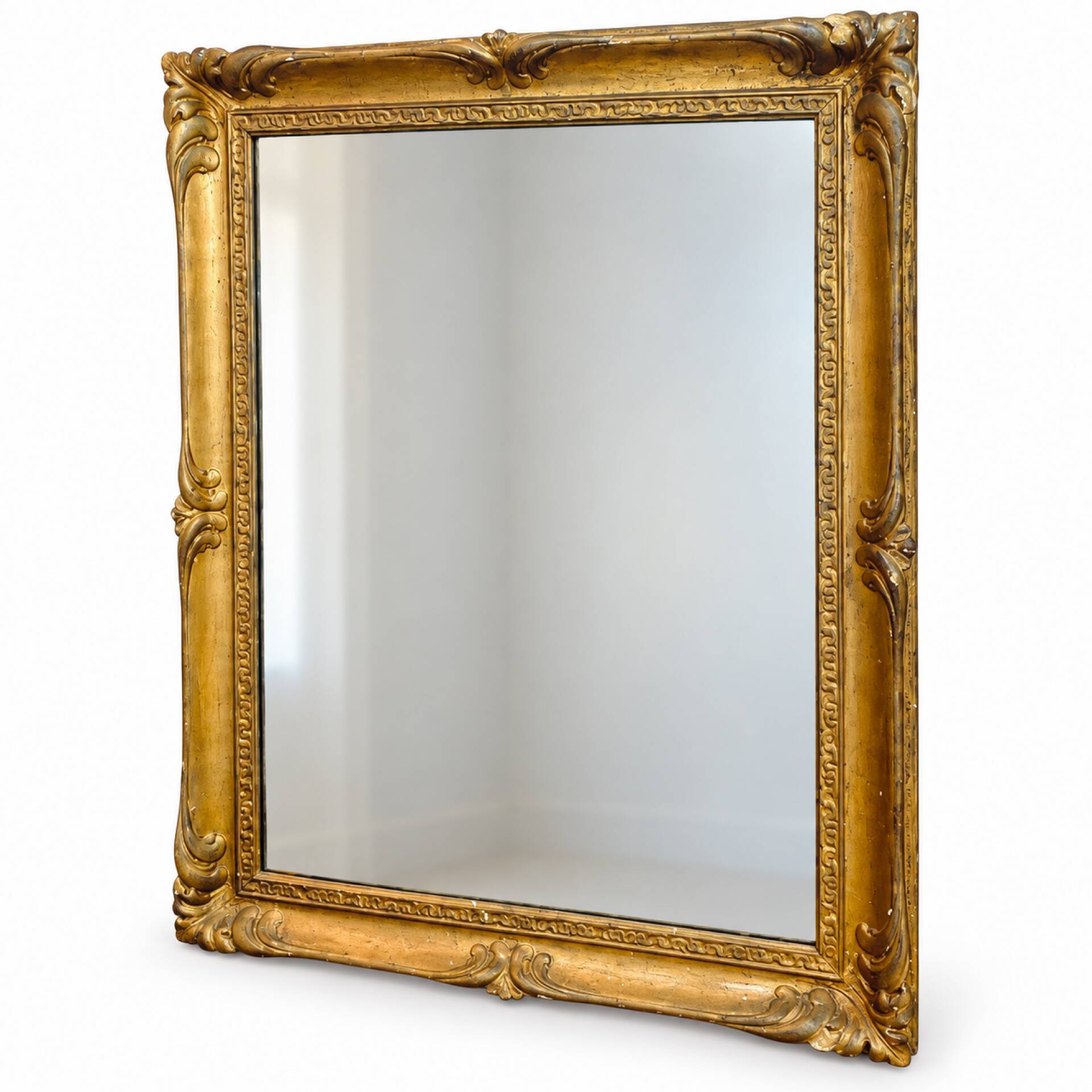 Antique mirror with a gilded frame and foliage decoration.