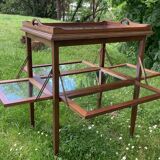 Glass-enclosed old tea table with wooden tray, bronze and brass