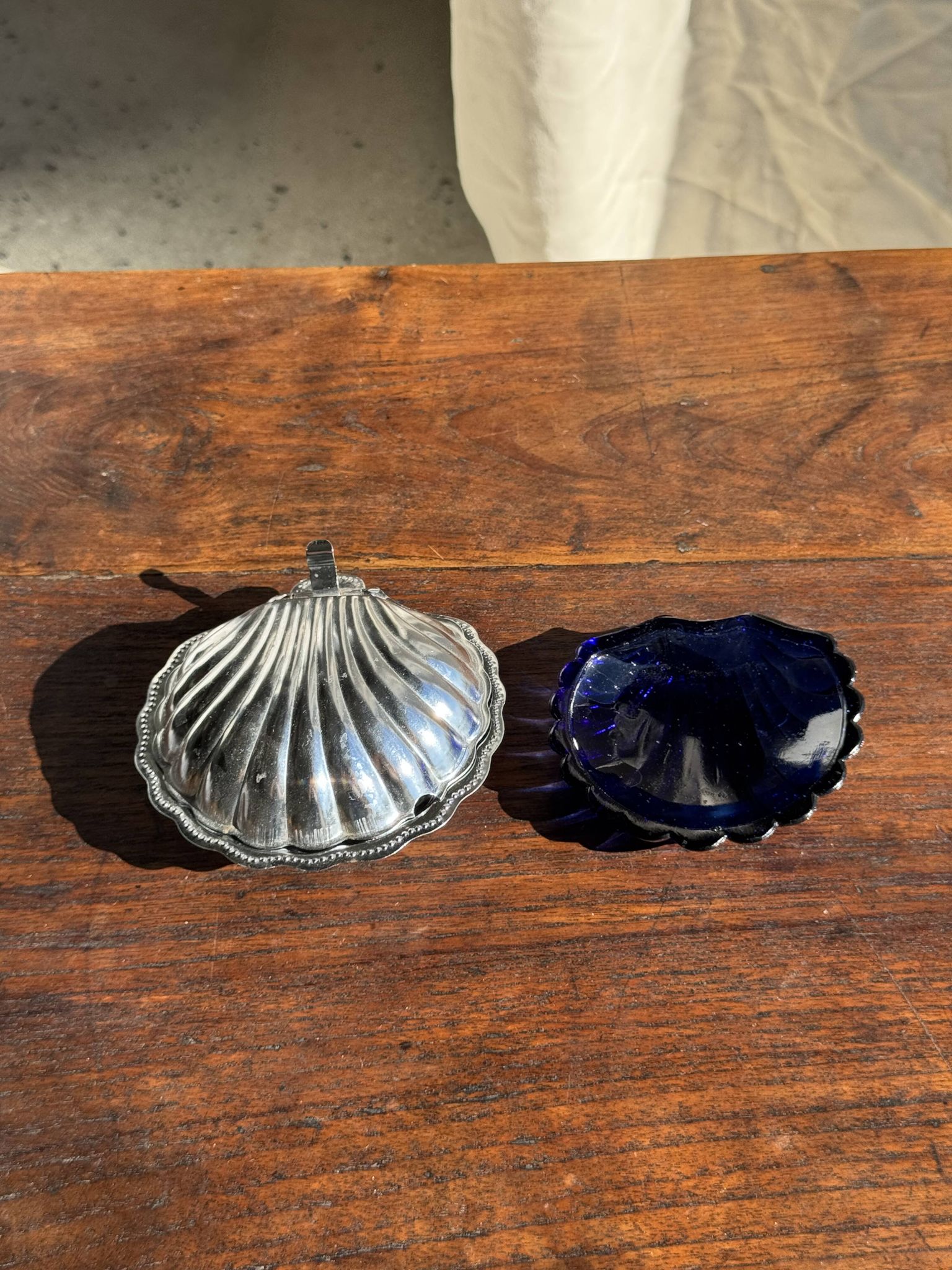 Vintage silver-plated shell butter dish with blue bowl.