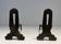Pair of Modernist Andirons in Cast Iron with Openwork Uprights and Tripod Bases