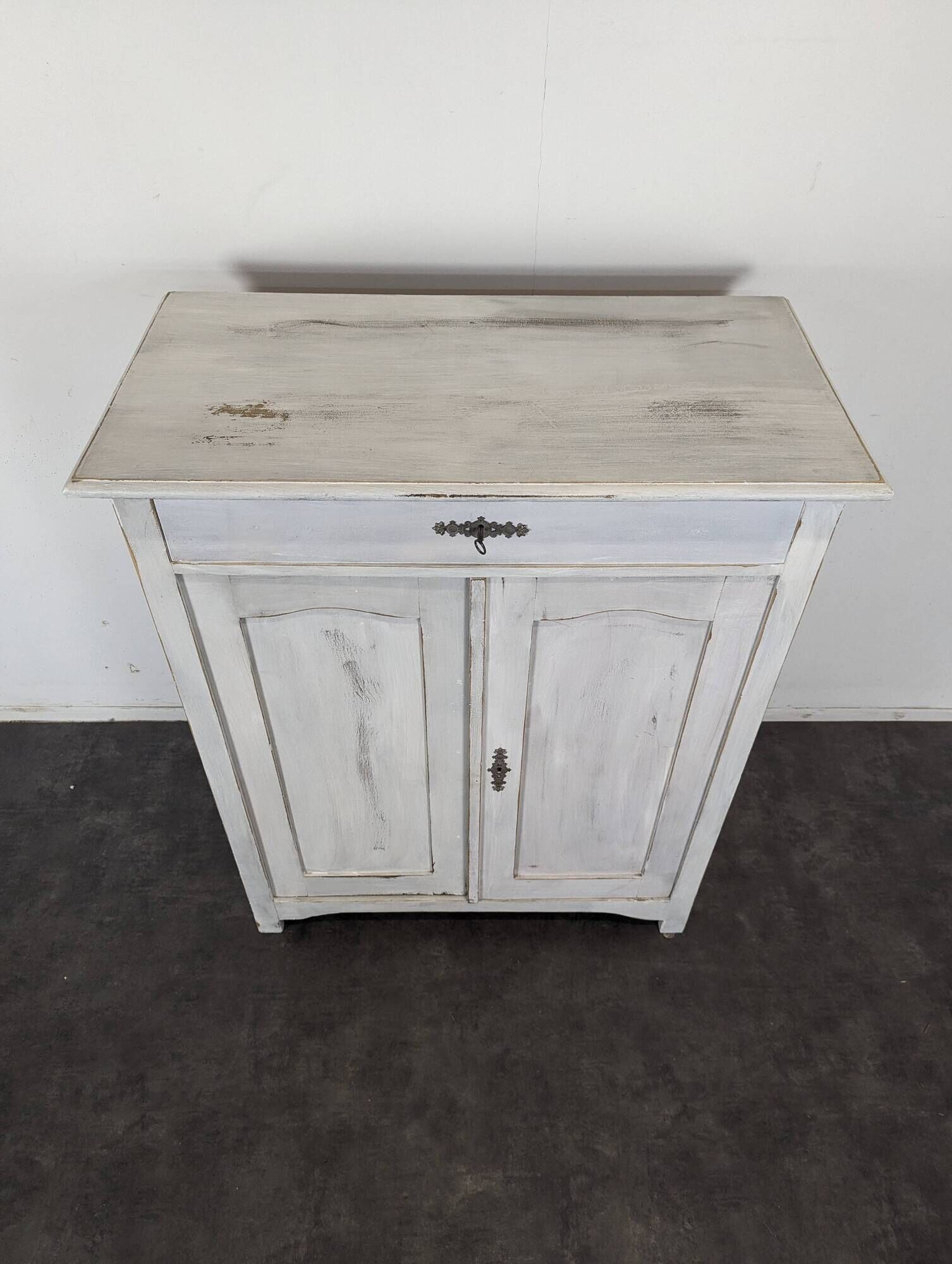 Small buffet with two doors and one drawer in white patinated wood.