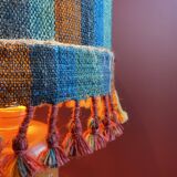 "Stoneware Bottle Lamp" with a multicoloured blue lampshade handwoven in India.