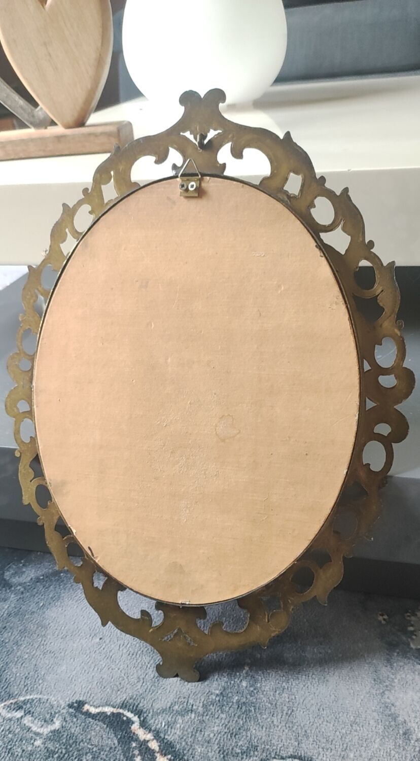 Antique oval mirror in Baroque/Rococo style. Made of gilded spelter. Dimensions: 42 x 31 cm