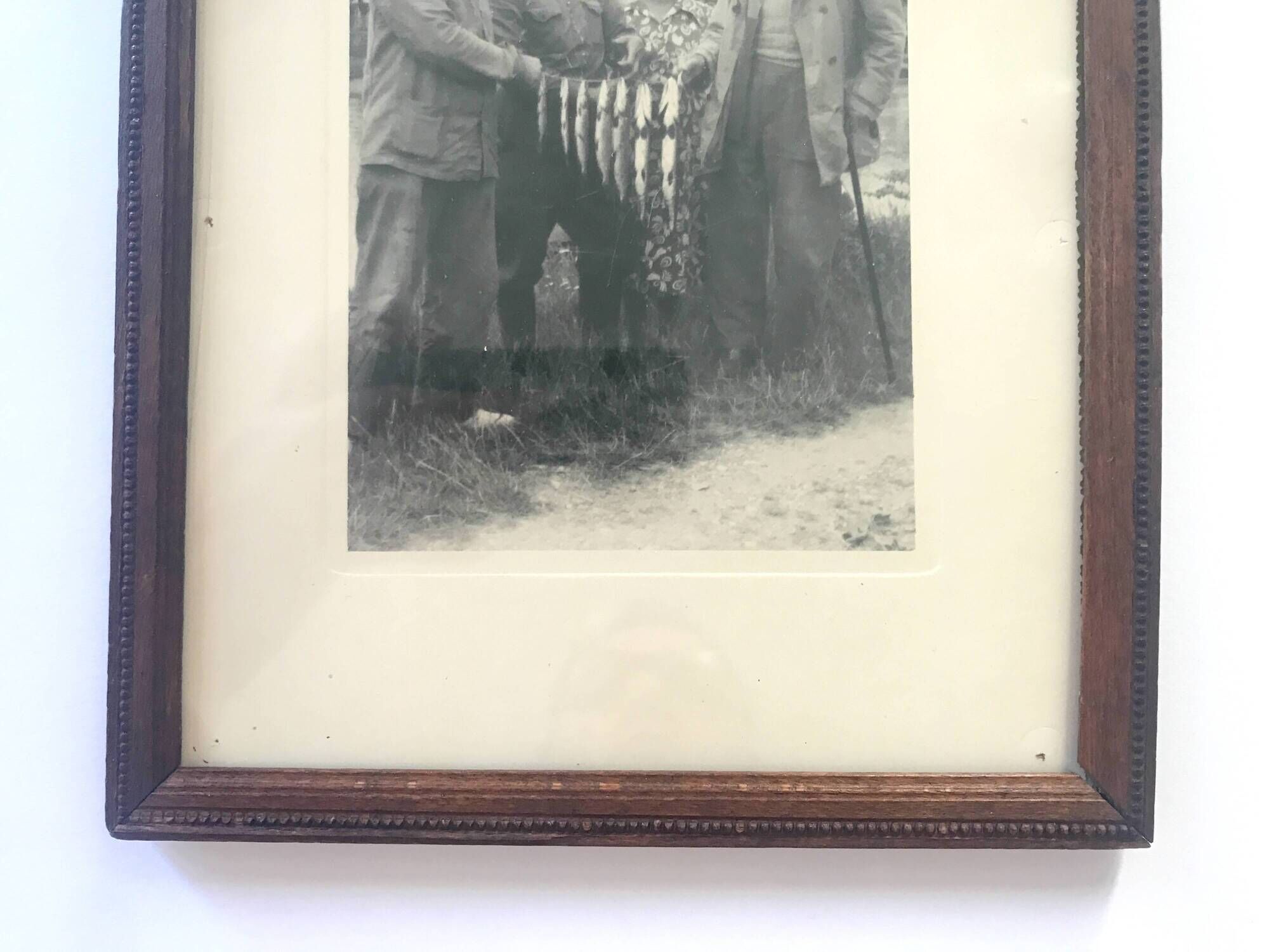 Fishing trophy with radiant faces, c. 1950. Black and white photograph.