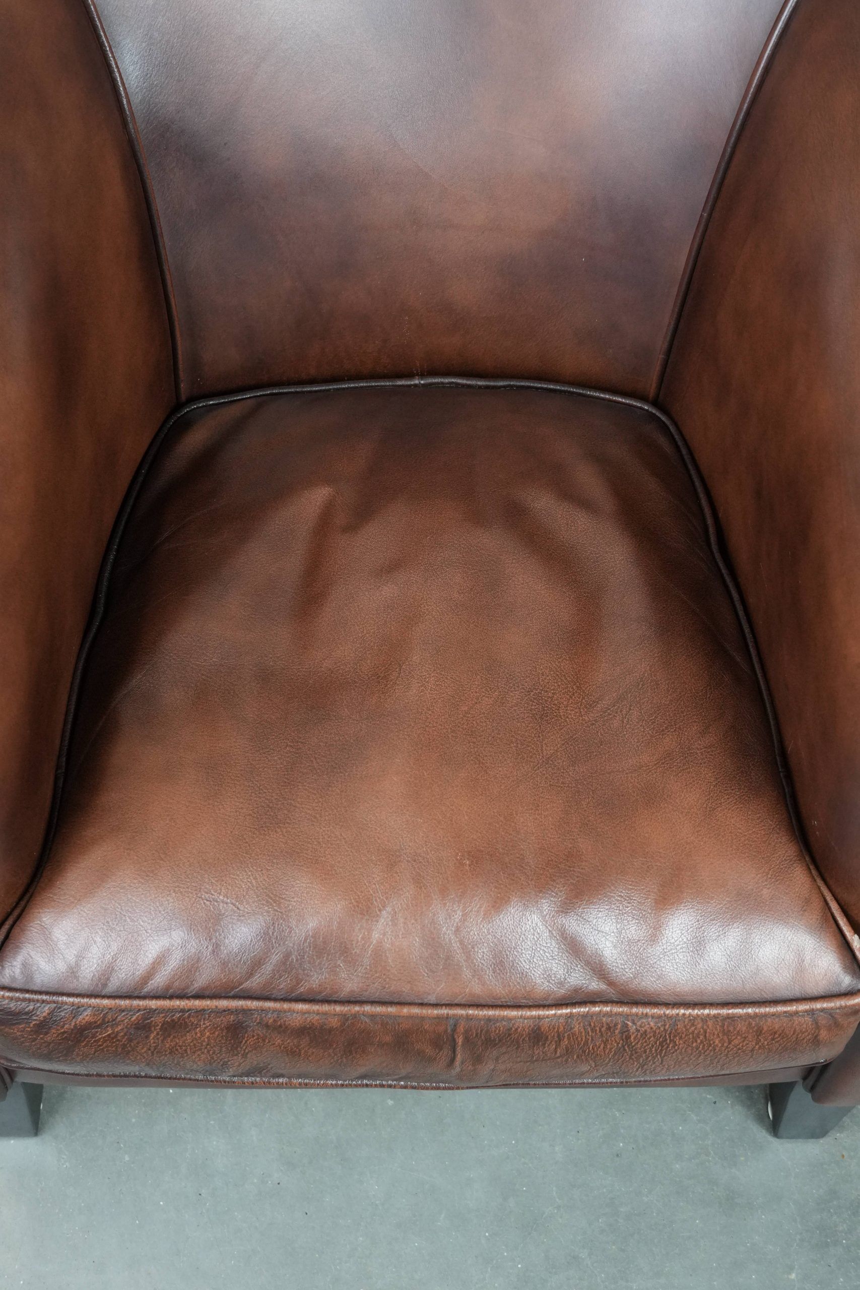 Great luxurious brown cowhide club armchair with matching piping