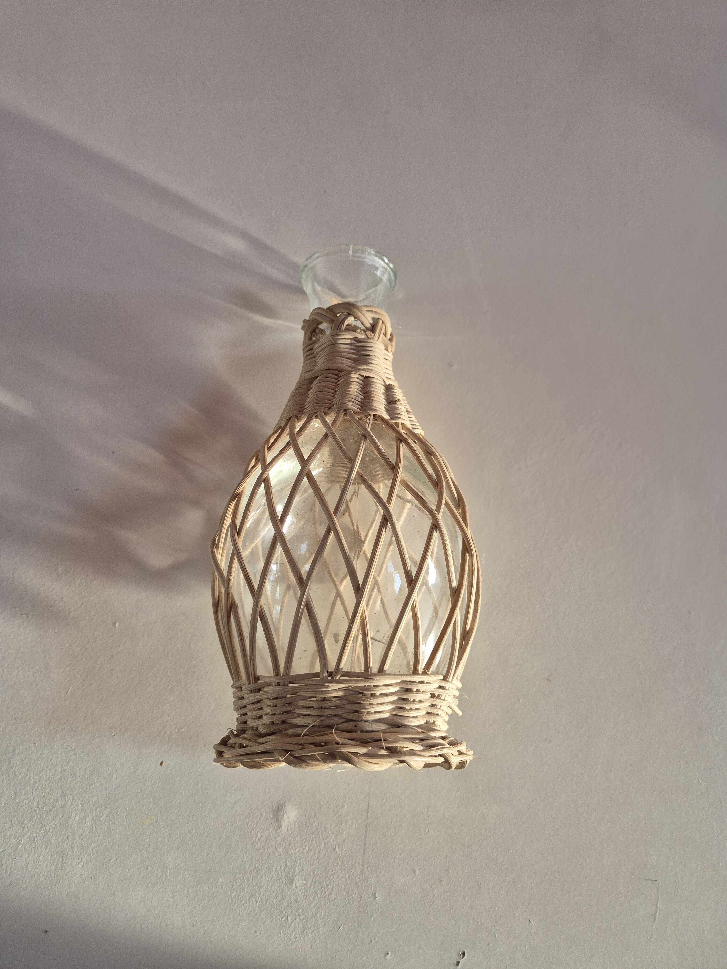 vintage glass vase surrounded by woven rattan