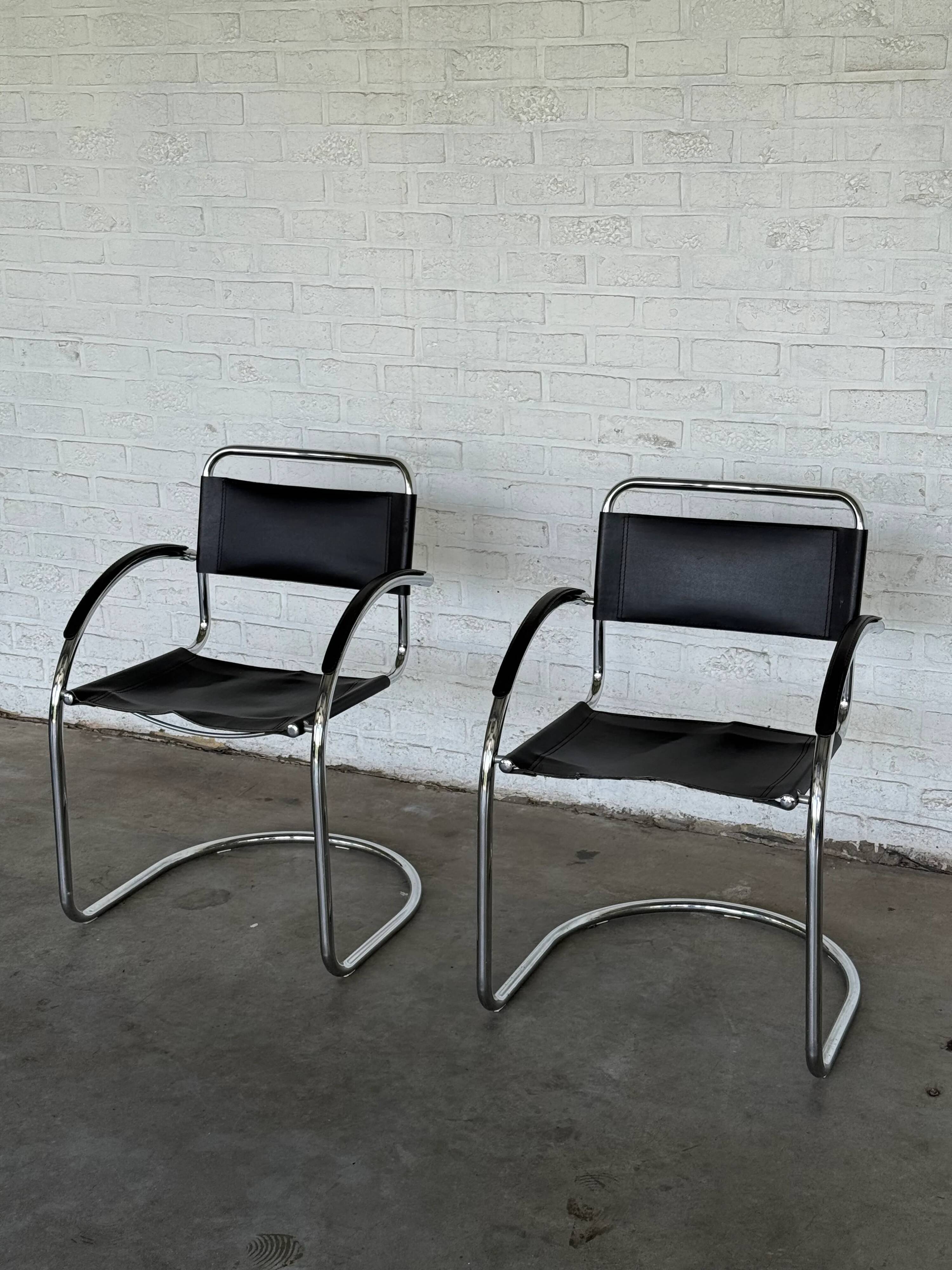 Vintage cantilever chairs in black saddle leather and chrome.