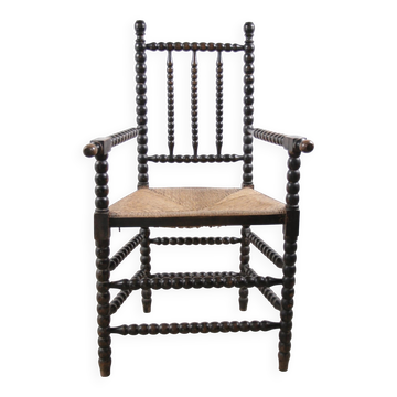 Black bobbin chair with armrests and rush seat – ca. 1900-1930