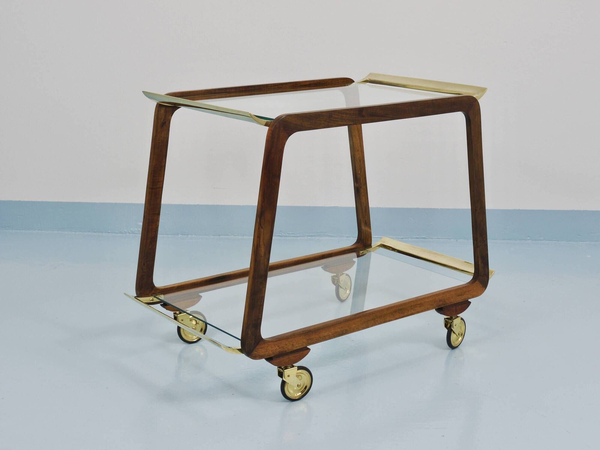 May include: A mid-century modern bar cart with a dark wood frame and two c