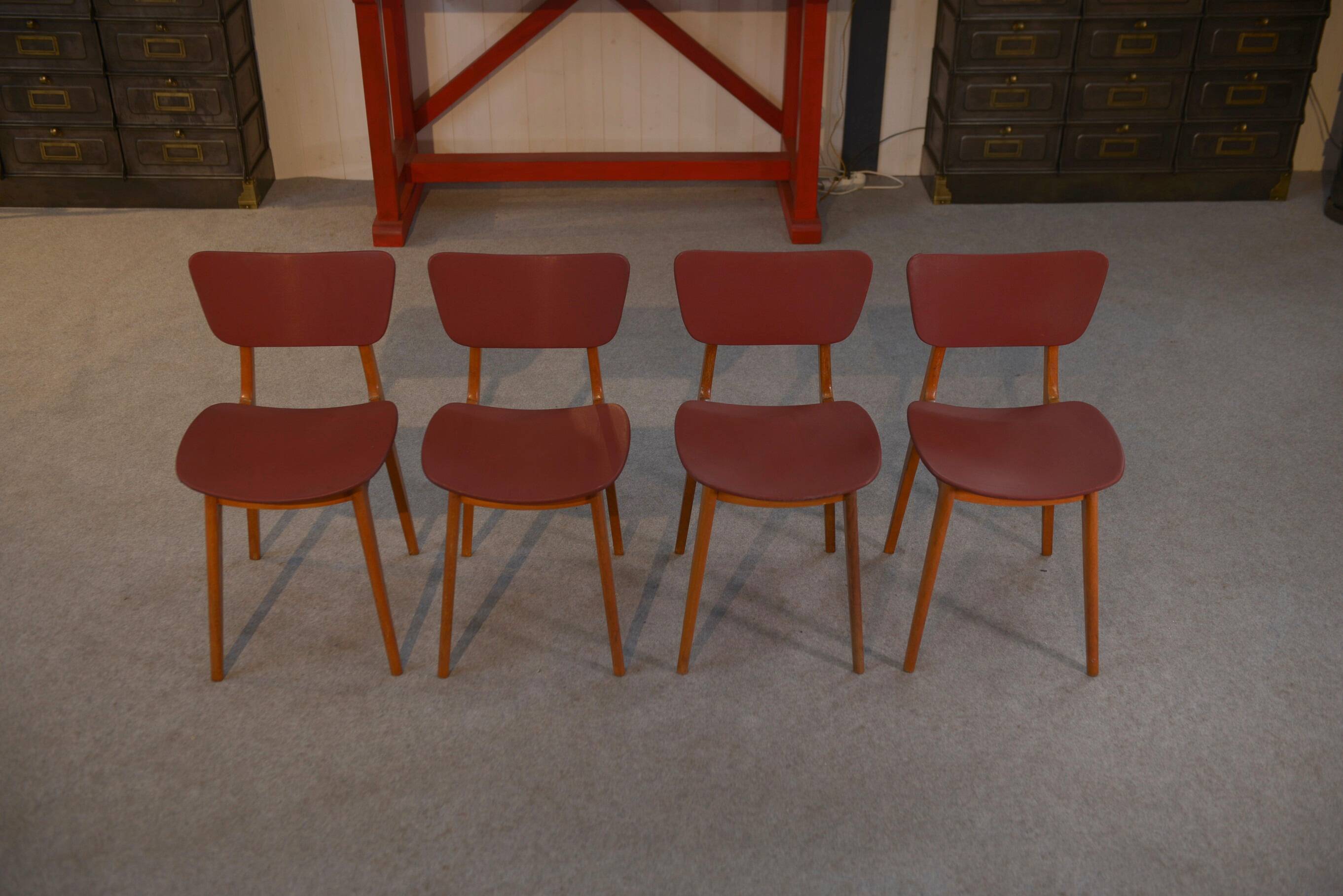 Set of 4 designer chairs in oak and red leatherette from the 1960s