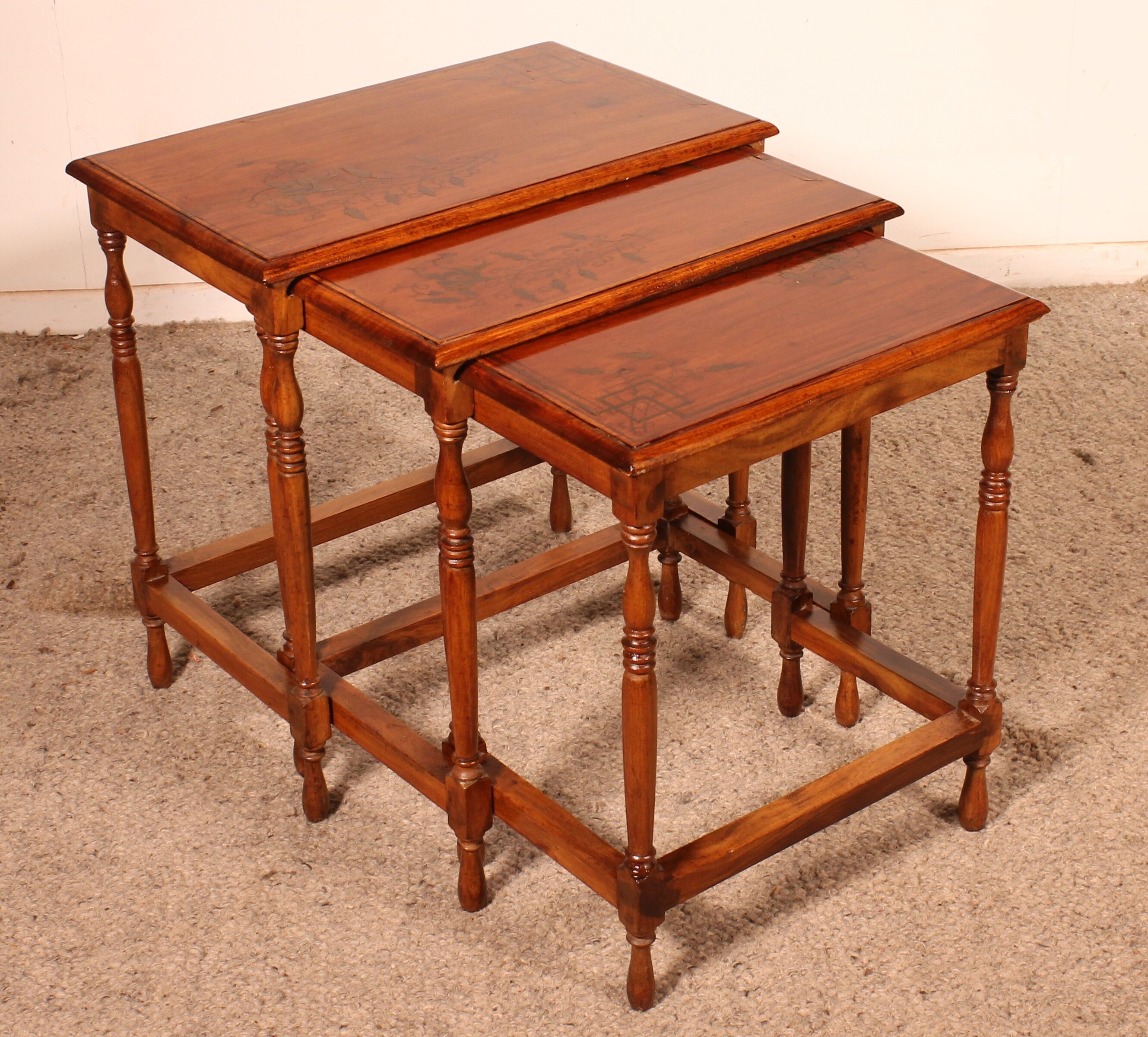 Nested tables in satin wood with brass inlays.