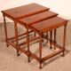 Nested tables in satin wood with brass inlays.