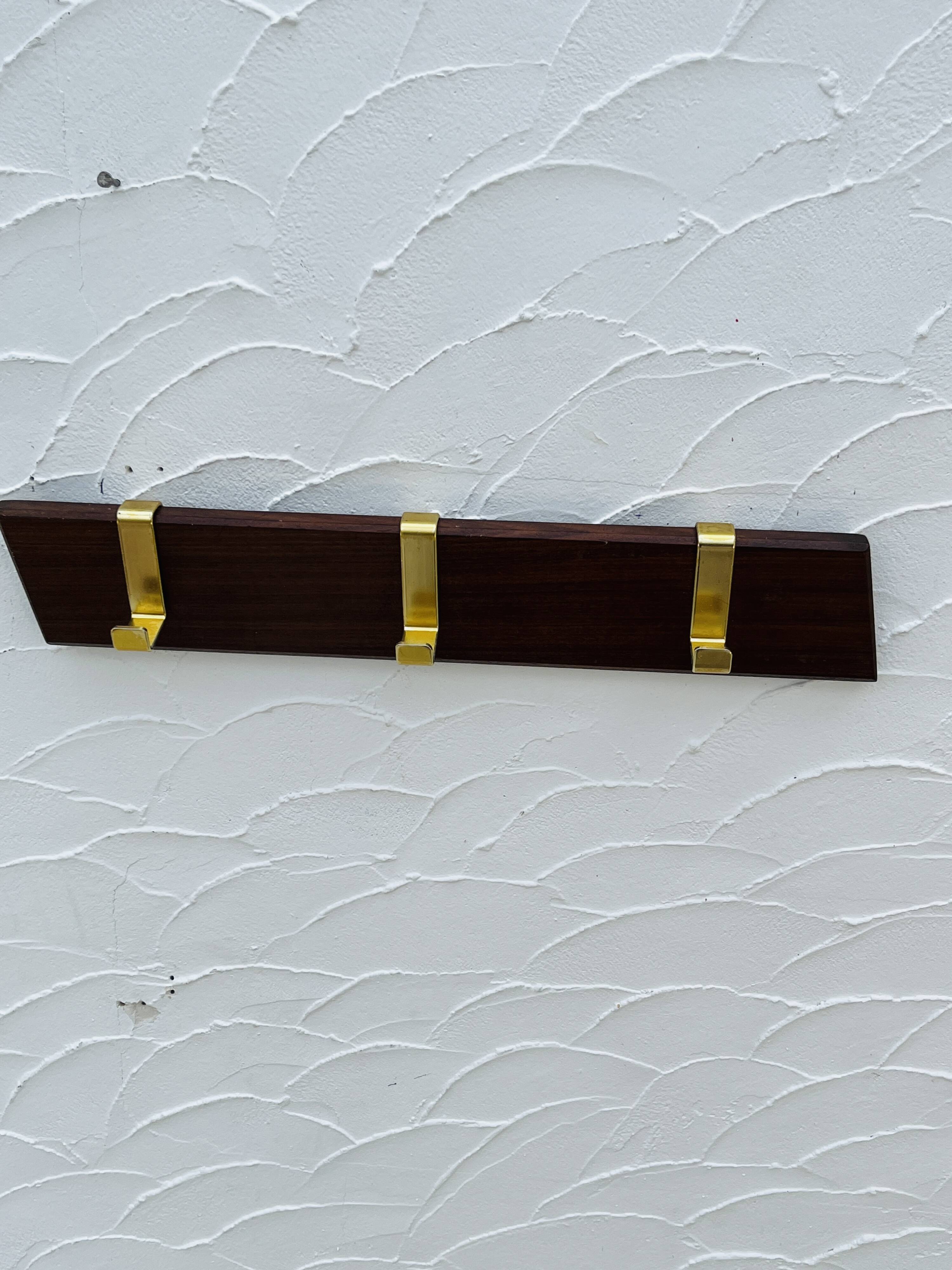 Vintage wooden and brass coat rack with 3 hooks from the 1960s.
