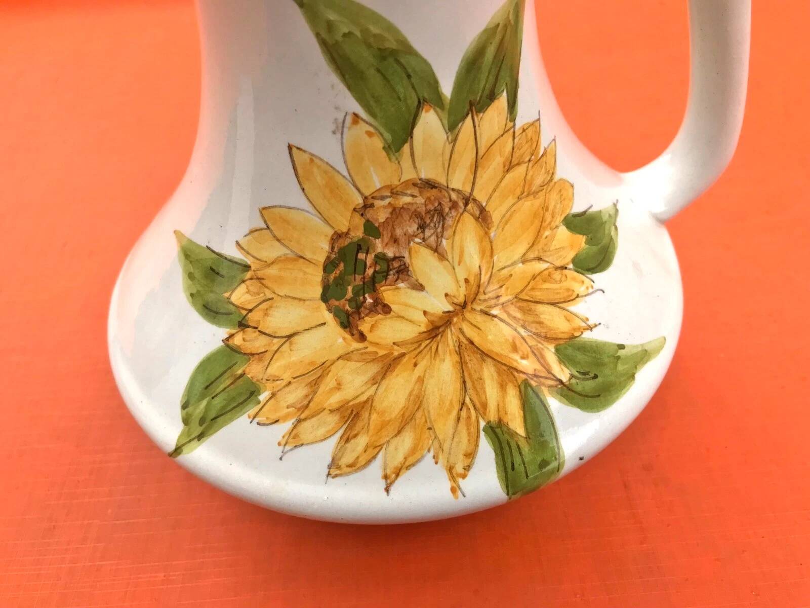 Antique glazed ceramic pitcher with sunflower decoration
