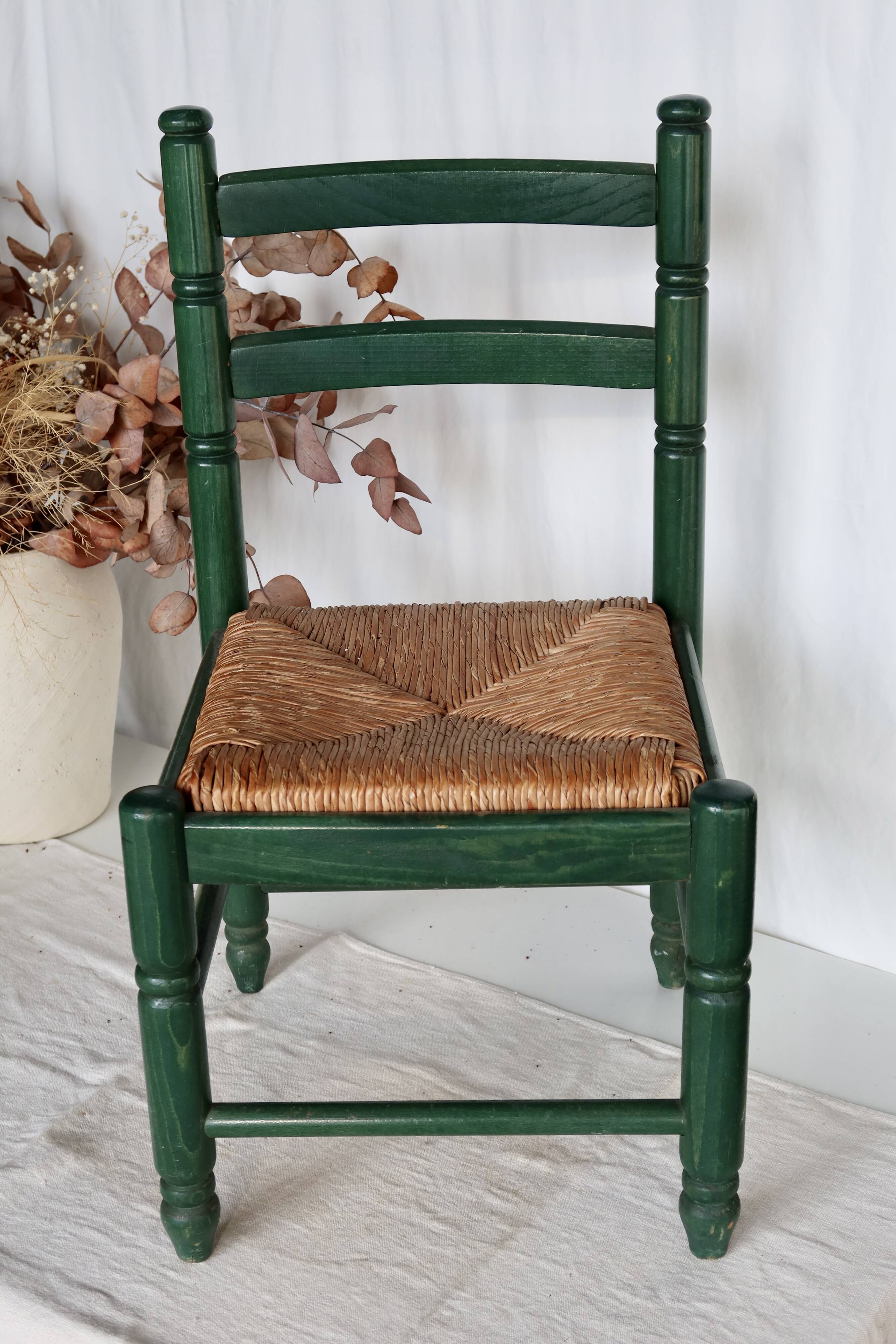 Vintage children's chair in green wood with a woven straw seat
