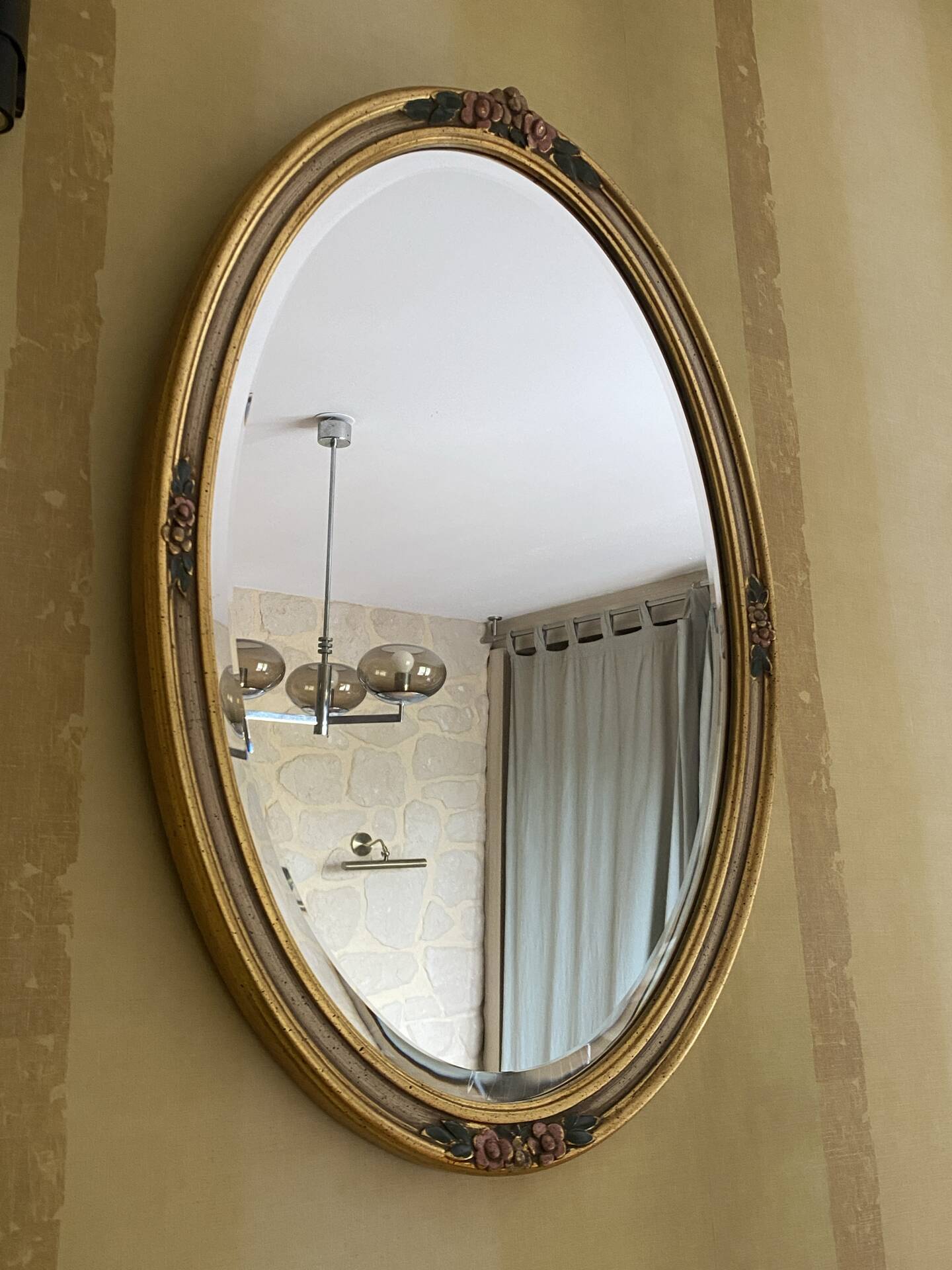 Oval wooden frame with floral decoration in gold.