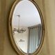 Oval wooden frame with floral decoration in gold.