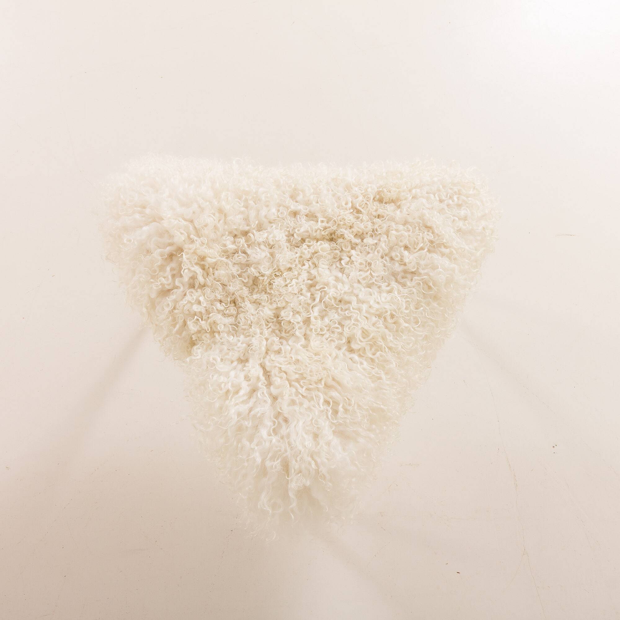 Scandinavian mid century triangular footstool in long hair sheepskin