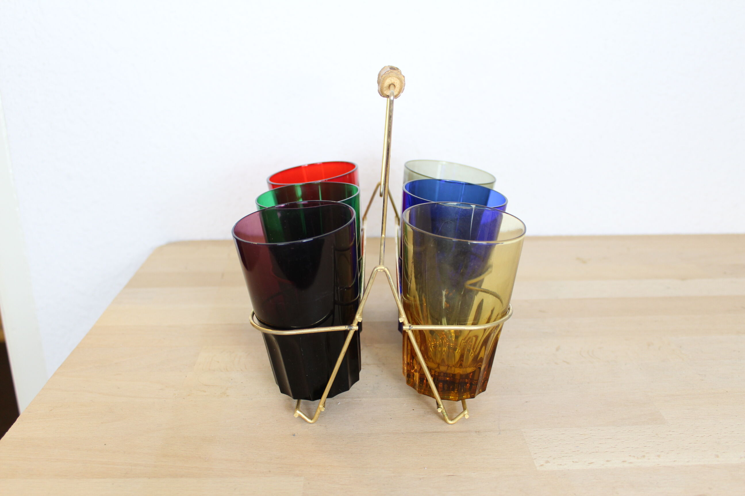 Set of 6 coloured glasses in their brass holder, basket