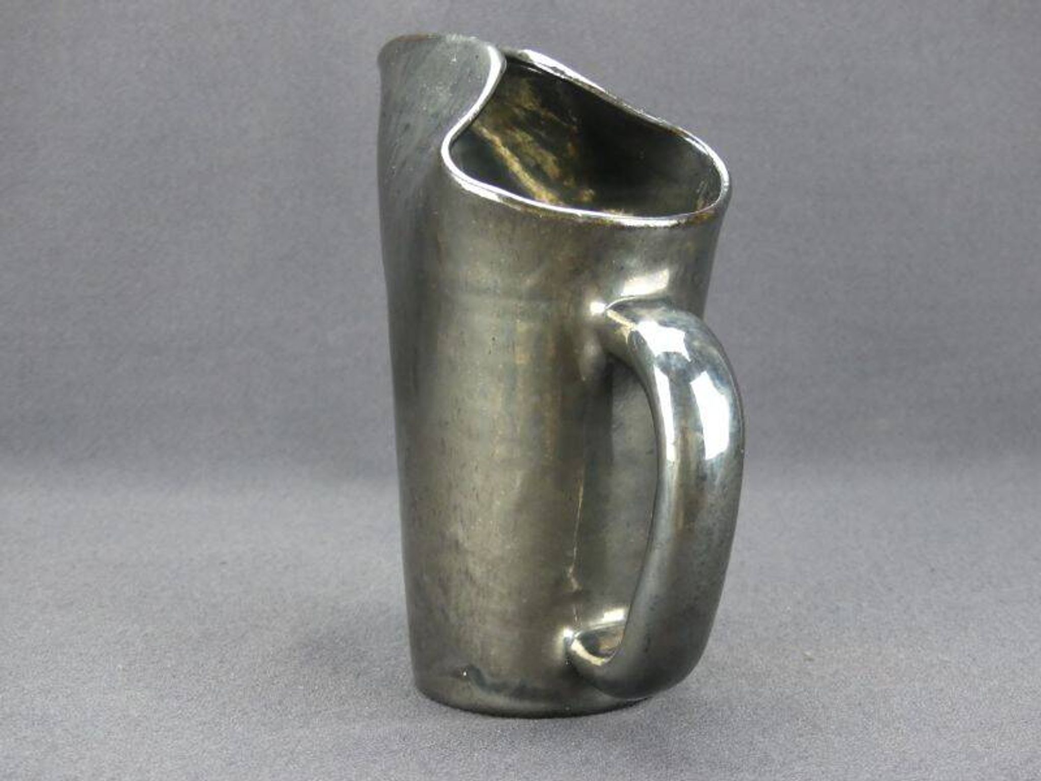 Old Biot, modernist pitcher in iridescent black ceramic.