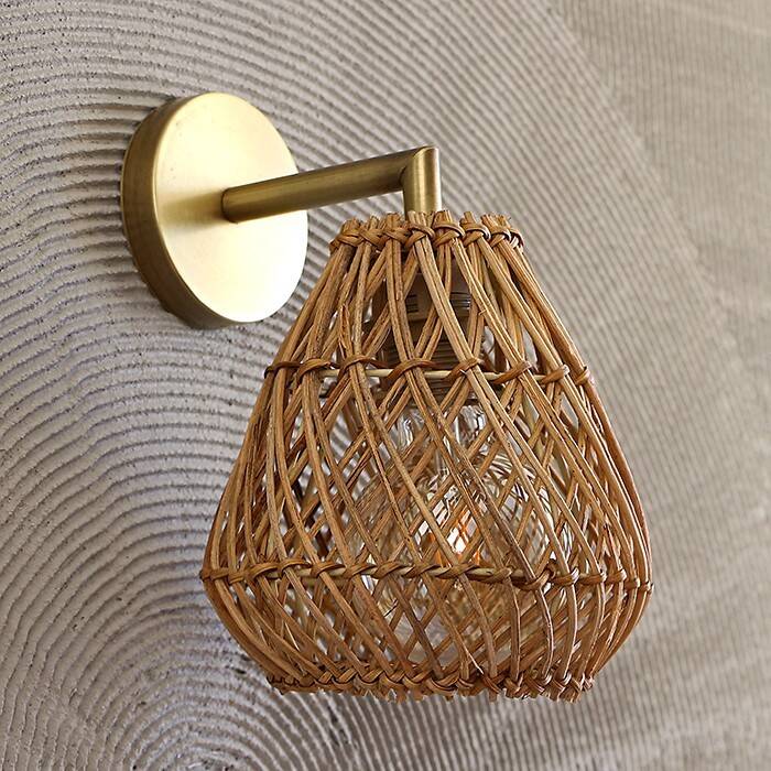 Golden bohemian wall lamp in woven rattan