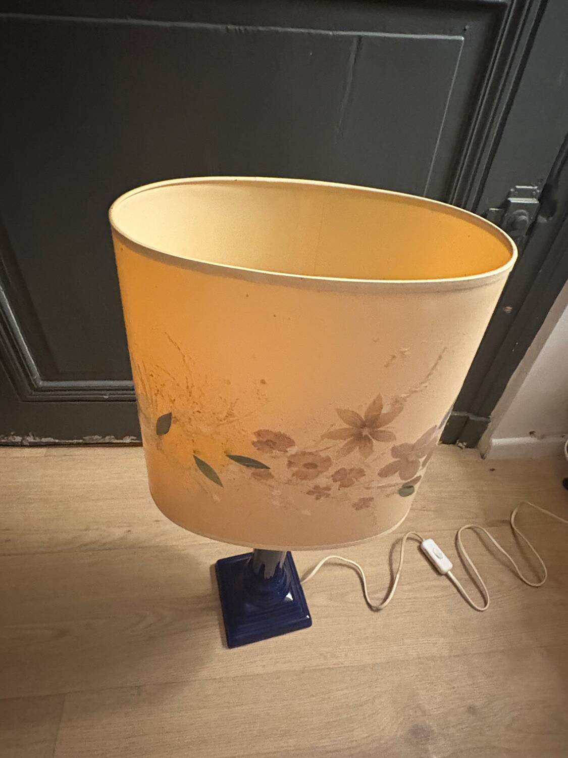 Corinthian column lamp base in blue with a lampshade of dried flowers.