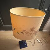 Corinthian column lamp base in blue with a lampshade of dried flowers.