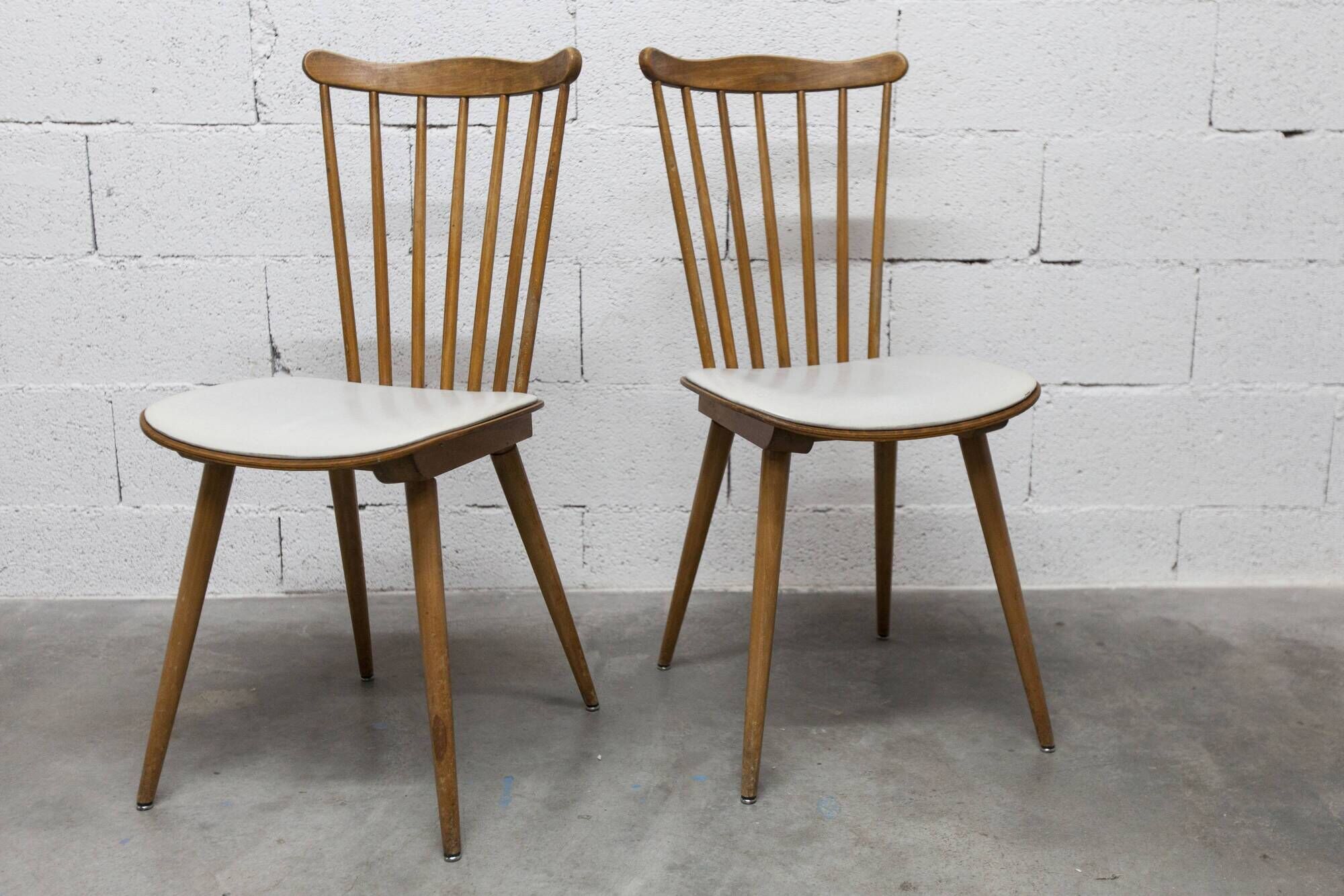 Pair of Baumann Menuet chairs, Honey patina, White skai seat