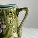 Green slip milk jug with floral patterns.