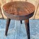 Wooden tripod stool.