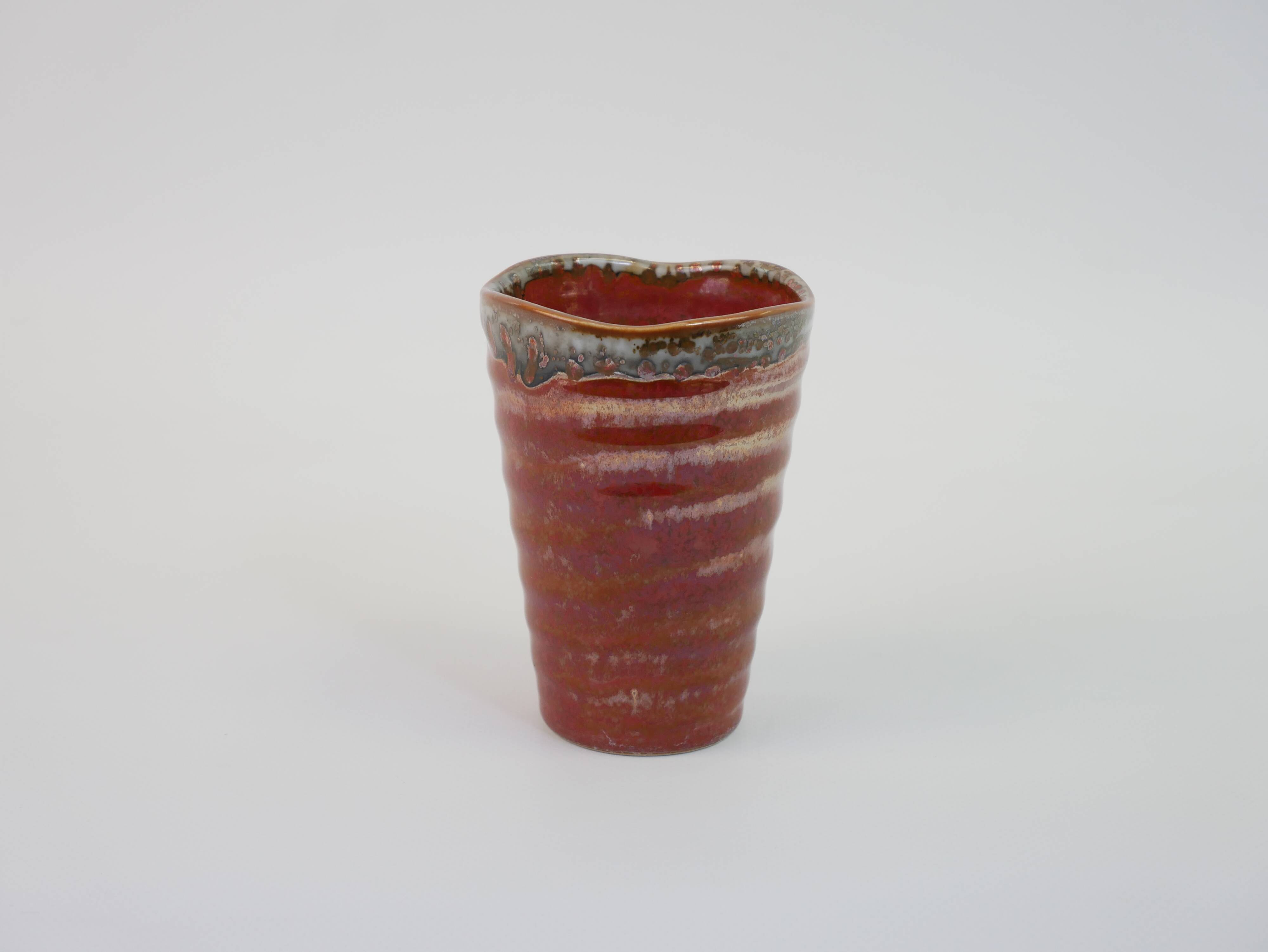 Small orange glazed ceramic cup