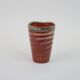 Small orange glazed ceramic cup